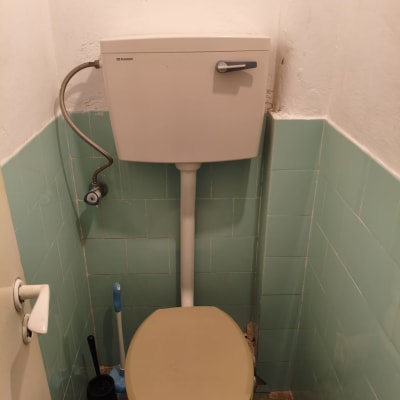 אסלה ומיכל הדחה בחדר שירותים קטן