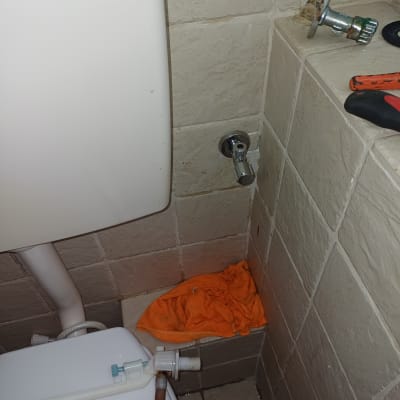 כלי עבודה וצינור ליד אסלה בשירותים