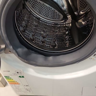 תוף מכונת כביסה פתוח עם תווית אנרגיה