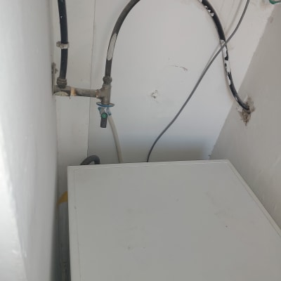 צינור שחור עם ברז על קיר לבן