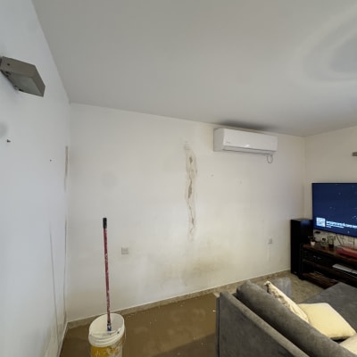 קיר עם סימני צבע ודלי צבע על הרצפה