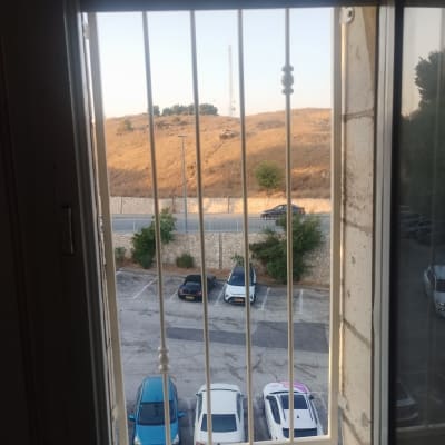 סורגי חלון לבנים עם נוף חיצוני