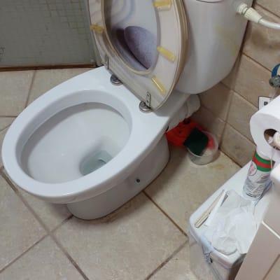 אסלה פתוחה עם ארגז כלים אדום על הרצפה