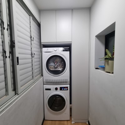 מכונת כביסה ומייבש כביסה מוערמים בחדר כביסה