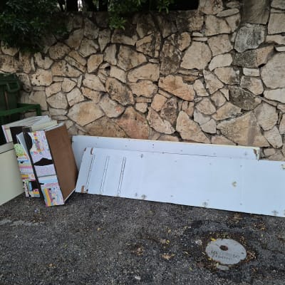 לוחות עץ וקרטון מונחים ליד קיר אבן