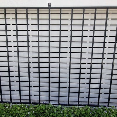 מסגרת מתכת שחורה עם סורגים על קיר לבן