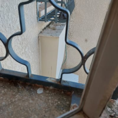 אדם עובד על איטום חלון עם סורגים