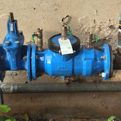 שסתום מים כחול עם ברזים ירוקים על צינור