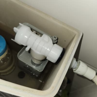 מנגנון פלסטיק לבן בתוך מיכל הדחה בשירותים