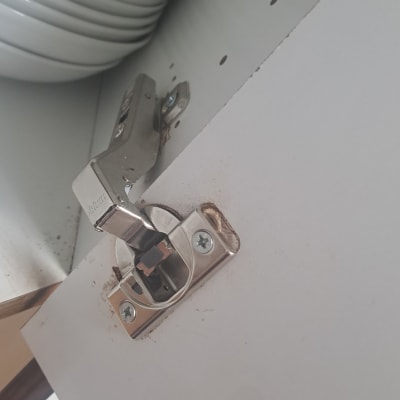 התקנת ציר ארון עם מנגנון טריקה שקטה בדלת ארון לבנה