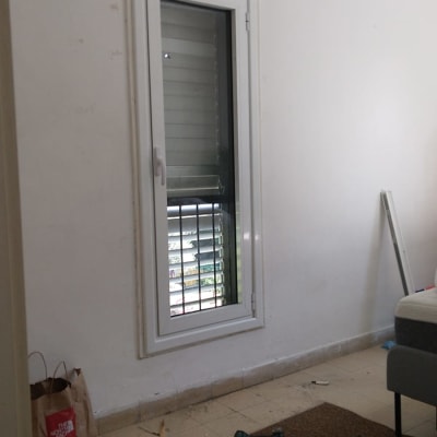 חלון אלומיניום עם תריסים וכלי עבודה על הרצפה