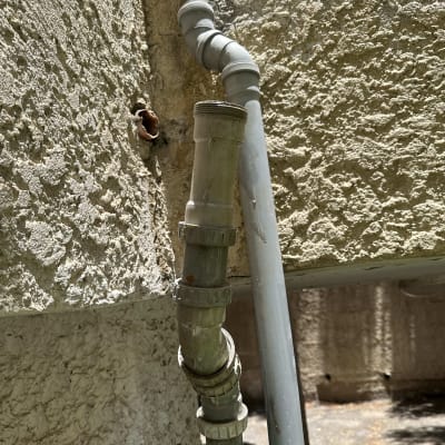 צינורות פלסטיק מחוברים לקיר בטון