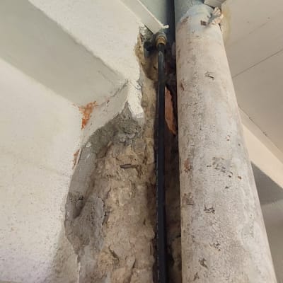 צינור מתכת ישן בקיר עם חיבורי צנרת