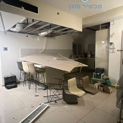 תקרת גבס קרסה על שולחן וכיסאות בחדר פנימי