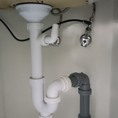צנרת פלסטיק מתחת לכיור עם חיבורים