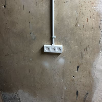 שקע חשמל על קיר עם חוטים חשופים