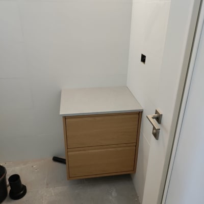 ארון עץ עם מגירות, צינור וכלי עבודה על הרצפה