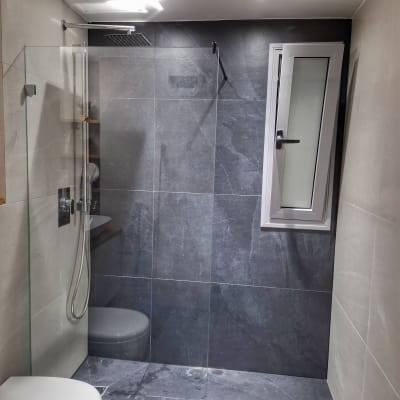 מקלחת עם ראש גשם, קירות אריחים וחלון קטן