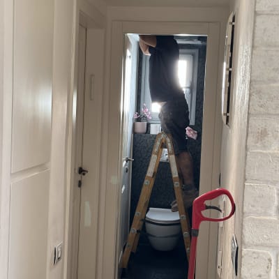 אדם על סולם מתקן מיזוג אוויר בתקרה