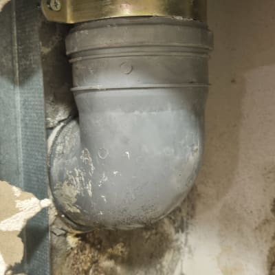 צינור פלסטיק אפור עם תושבת מתכת בקיר