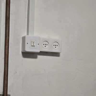 שקע חשמל ומתג על קיר לבן