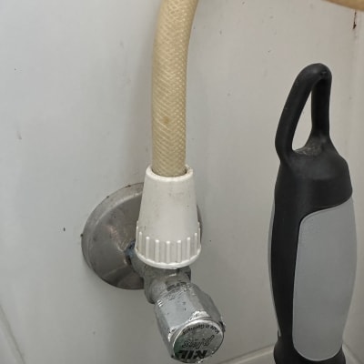 צינור מים מחובר לשסתום על קיר לבן