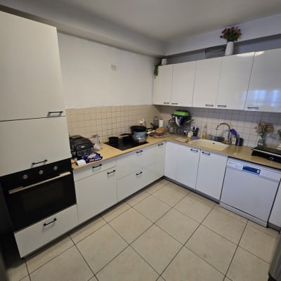 מטבח עם ארונות לבנים וכלי מטבח על השיש