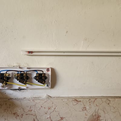 חוטי חשמל צבעוניים בקופסת חיבורים פתוחה על קיר