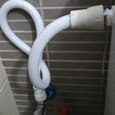 צינור מים לבן מחובר לברז מתכת