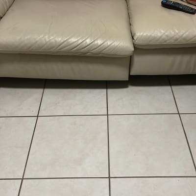 ספה מרופדת עם כרית ושטיח מרצפות