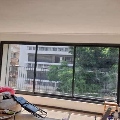 סלון דירה עם חלון זכוכית רחב הפונה למרפסת