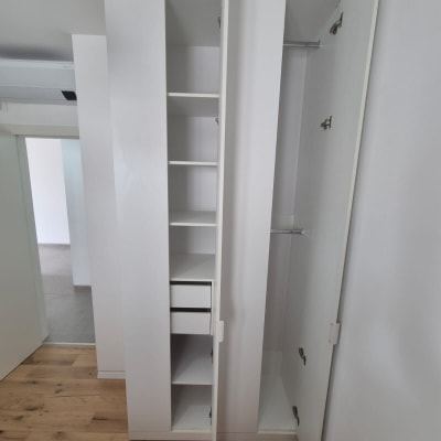 ארון לבן עם מדפים ודלתות פתוחות