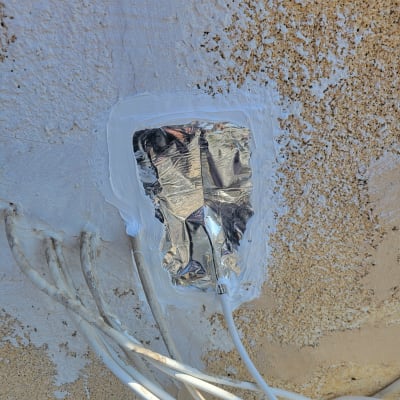 נייר כסף ואיטום לבן על קיר עם חוטים