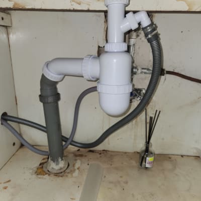 צנרת מתחת לכיור עם חיבורים ואביזרים