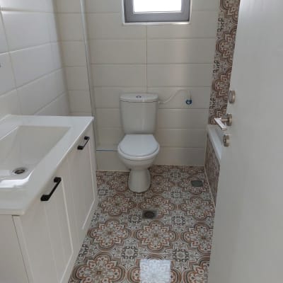 חדר אמבטיה עם כיור, אסלה ורצפה מעוטרת