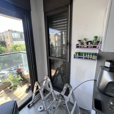 תריסים סגורים על חלון זכוכית עם מסגרת כהה