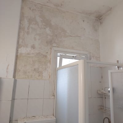 קיר מתקלף עם סימני רטיבות בחדר אמבטיה