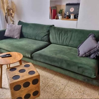 ספה ירוקה עם כריות ושולחן עץ קטן