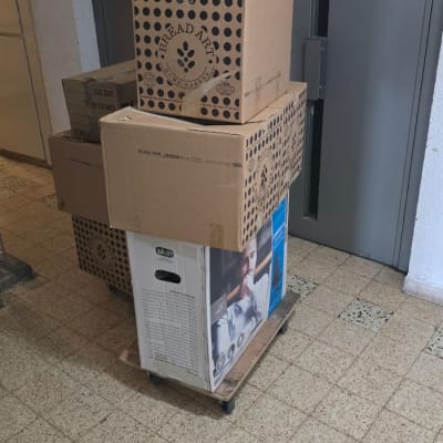 ארגזים ארוזים על עגלת הובלה במסדרון בניין