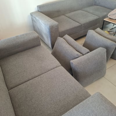 ספות אפורות עם כריות מונחות על הרצפה