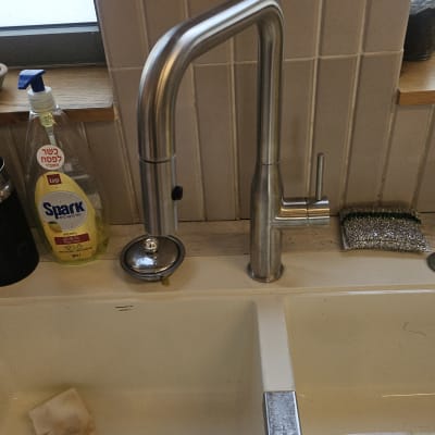 ברז נירוסטה בכיור מטבח עם ספוג ונוזל ניקוי