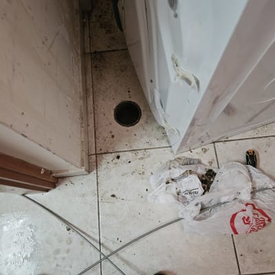 כלי עבודה של אינסטלטור ליד חור ניקוז ברצפה