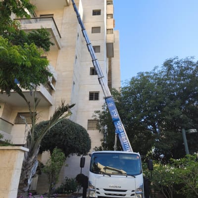 משאית עם מנוף ליד בניין מגורים