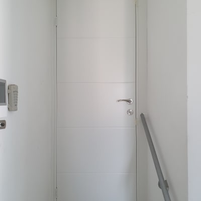 דלת לבנה עם ידית מתכת ומנעול