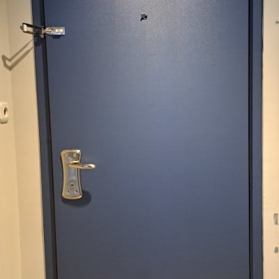 דלת כחולה עם ידית מתכת ובריח ביטחון