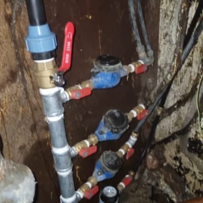צינורות מים עם ברזים אדומים ומדי מים כחולים