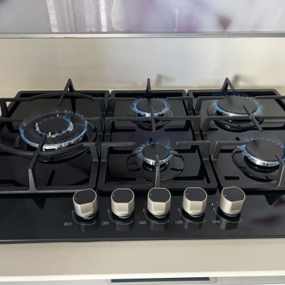 כיריים גז עם להבות כחולות במטבח מודרני