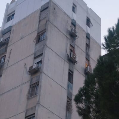 בניין גבוה עם מזגנים מותקנים על הקירות החיצוניים