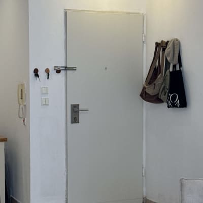 דלת לבנה עם ידית, מתלה תיקים על הקיר