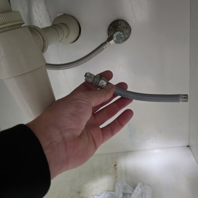 תיקון צינור מתחת לכיור עם יד מחזיקה צינור